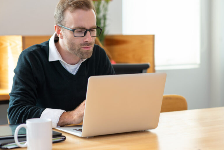 Mann verfasst Anschreiben an seinem Laptop