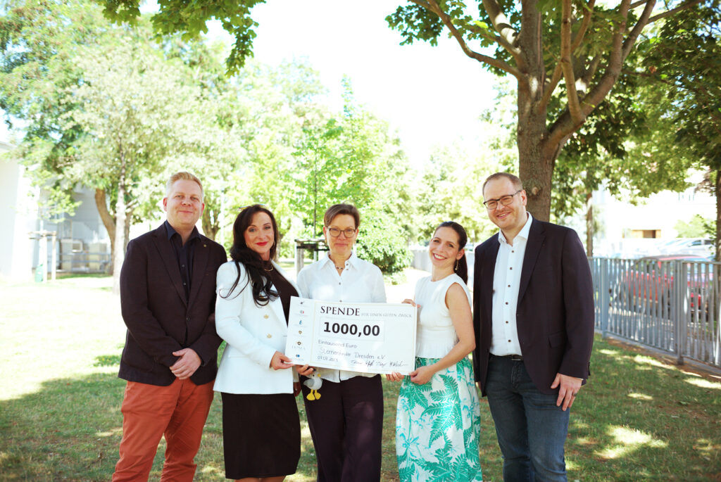 Eine Delegation der Five Hunters Group übergibt einen Scheck an den Sternenkinder Dresden e. V.